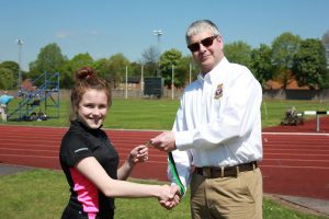 Cadet N. Wake collecting her silver medal from Wing Commander Andy Griffin Officer Commanding West Mercian Wing for coming 2nd in 200m in her age category during the athletics event.