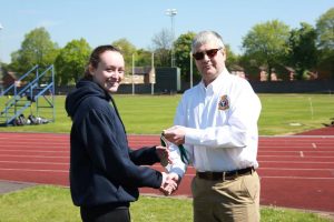 Cadet Corporal A. Bryan collecting her gold medal from Wing Commander Andy Griffin Officer Commanding West Mercian Wing for coming 1st in 400m for her age category during the athletics event.