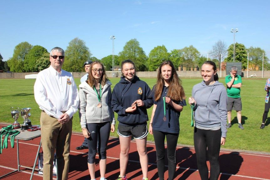 Cadet Corporal A. Cooper, Cadet Flight Sergeant C. Weetman, Cadet Corporal C. Walthorne and Cadet Corporal J. Tucker collecting their medals from Wing Commander Andy Griffin Officer Commanding West Mercian Wing for coming 3rd in the relay for their age category during the athletics event.