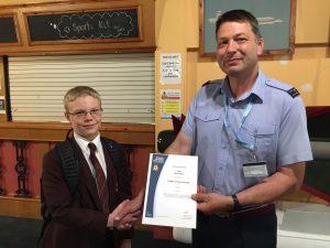 Cadet R. Kettle collecting his 'Cadet of the month' certificate from Flight Lieutenant Giles Vince RAFVR(T)